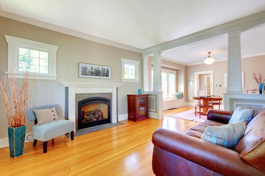 Wohnzimmer mit großer Ledercouch auf gemütlichem Dielenboden vor dem Kamin