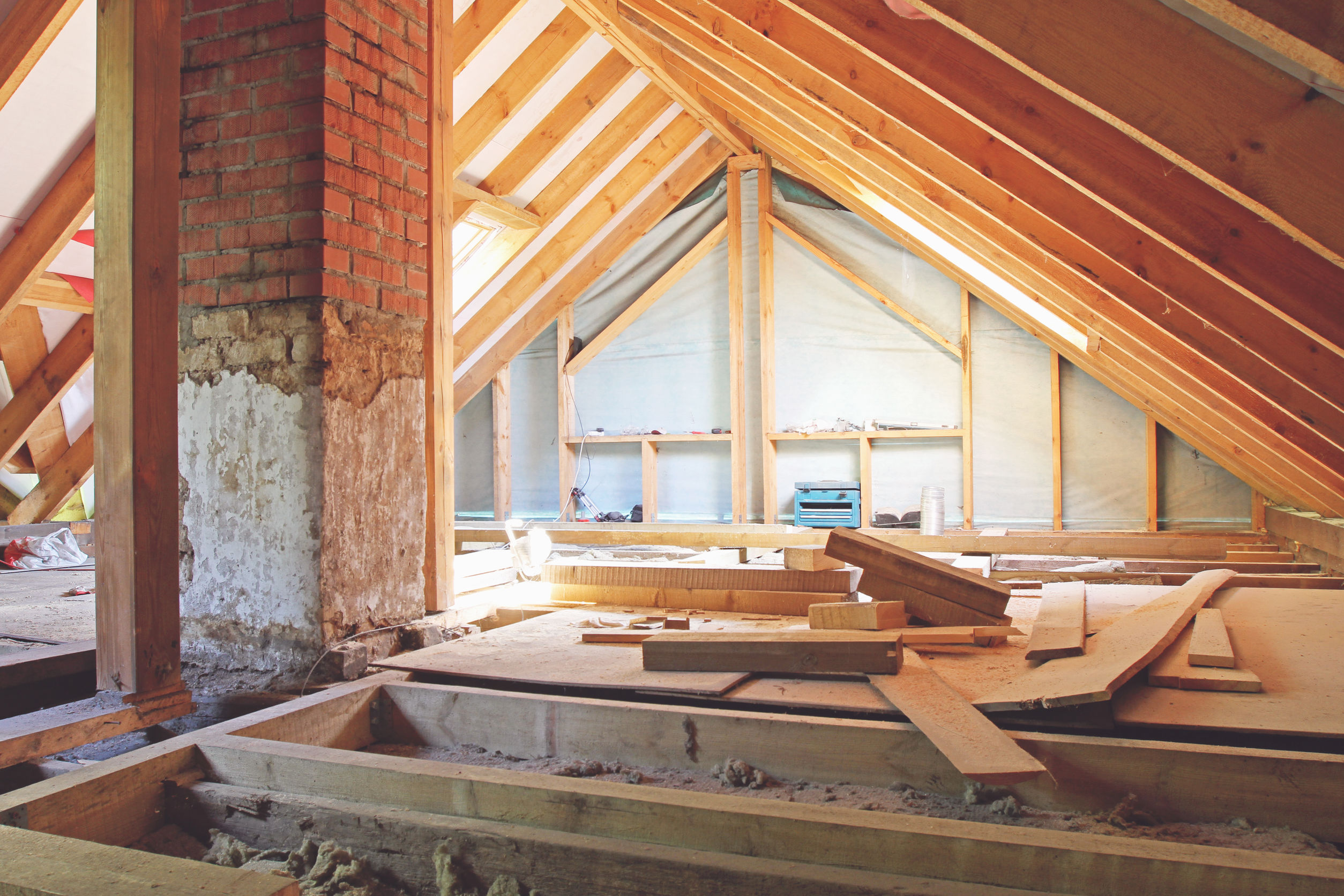 Bild zeigt einen Dachboden der gerade ausgebaut wir mit Dämmung zwischen den Dachspanten und einem Holzfußboden