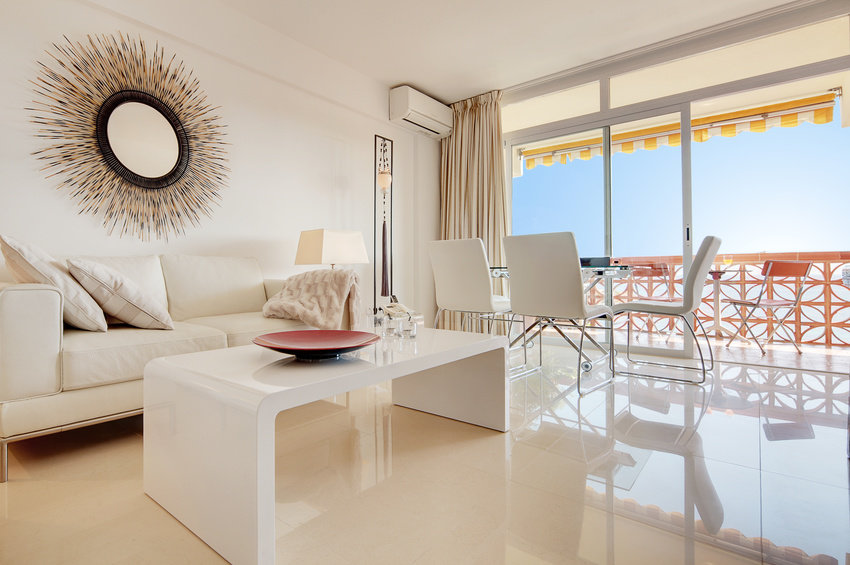 Couchgarnitur mit Tisch steht im Wohnzimmer auf einem hochglänzenden Fußboden